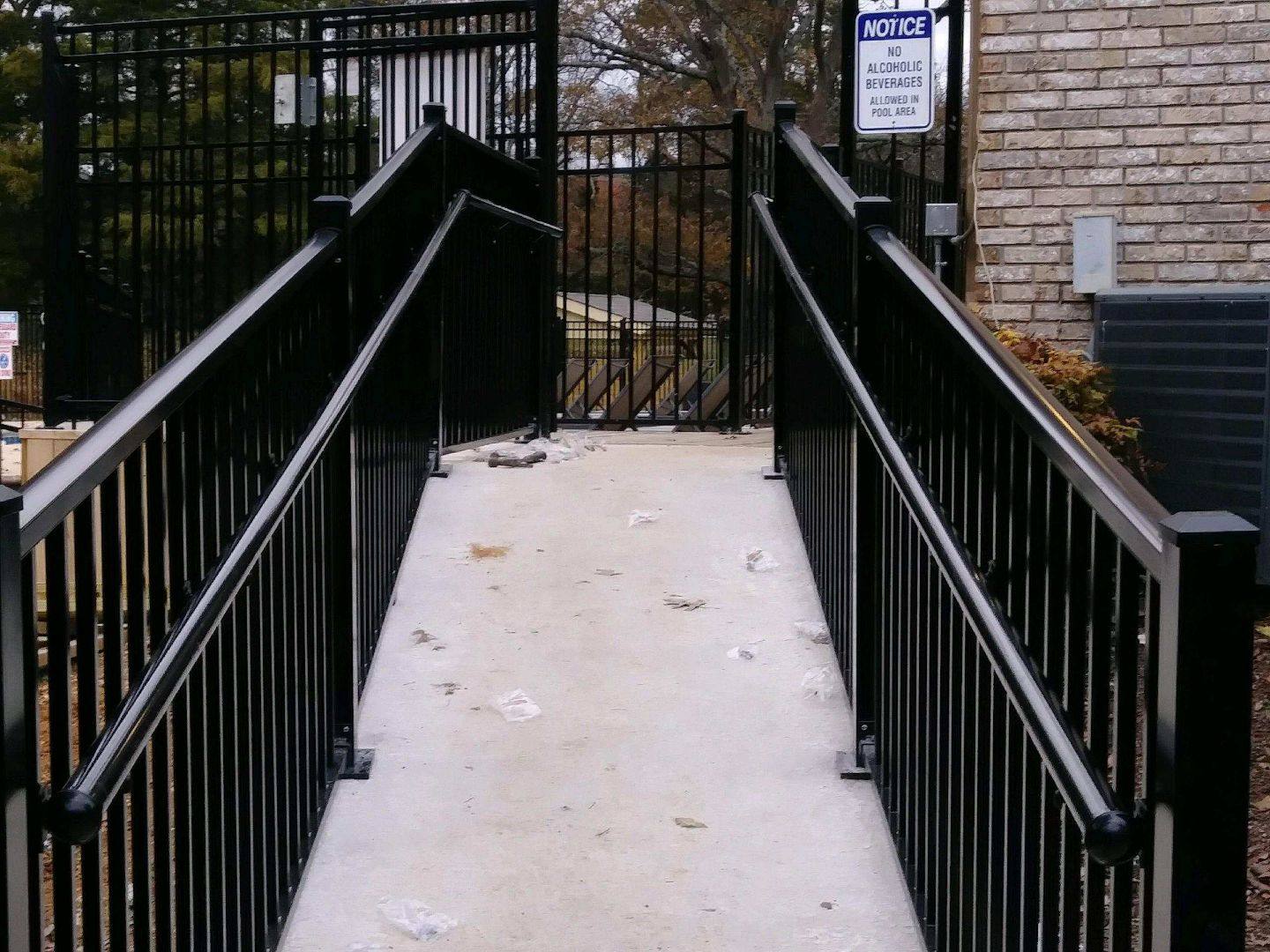 Black aluminum railing along a concrete ramp