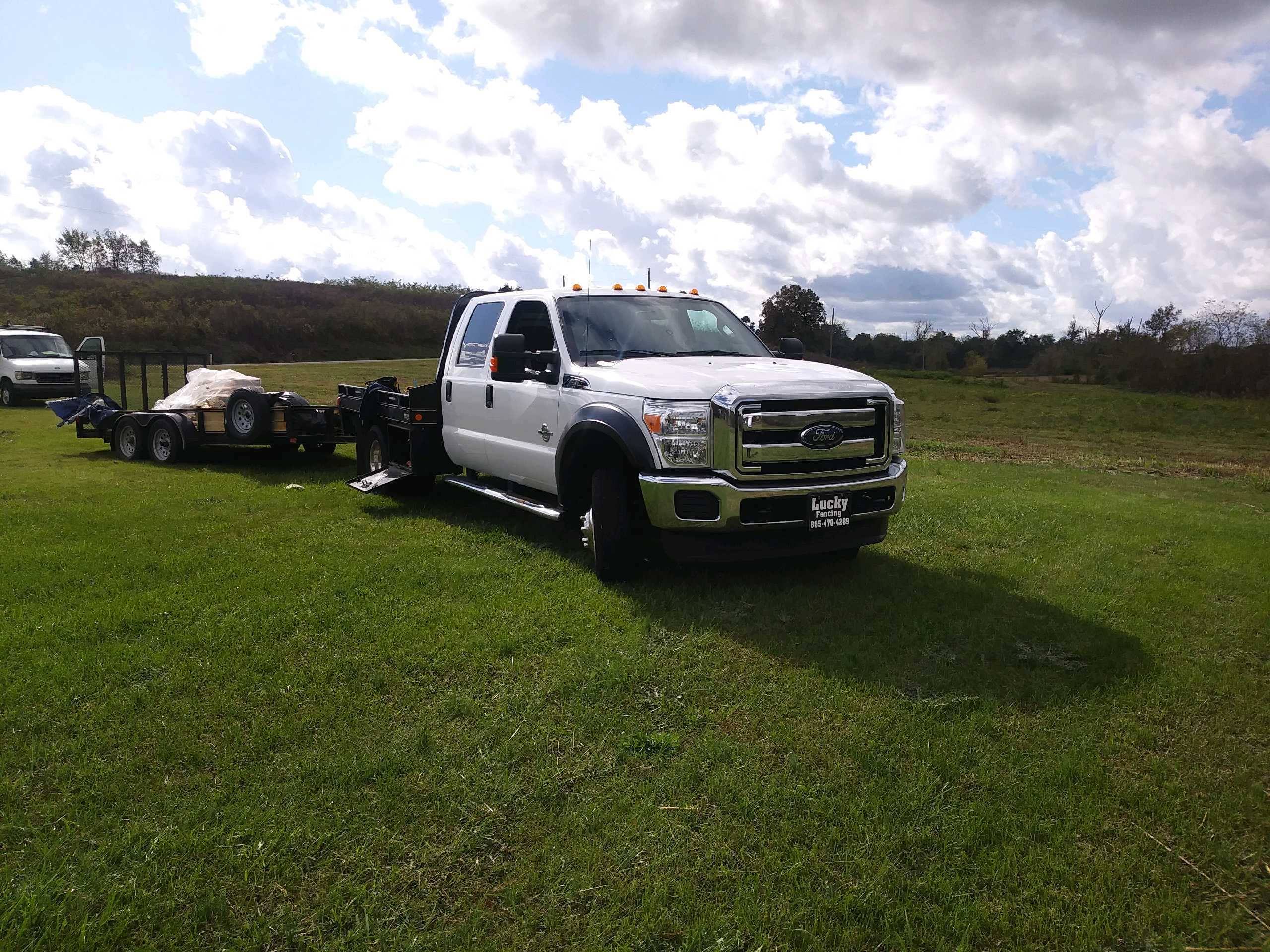 Lucky Fencing work truck and trailer parked on a job site