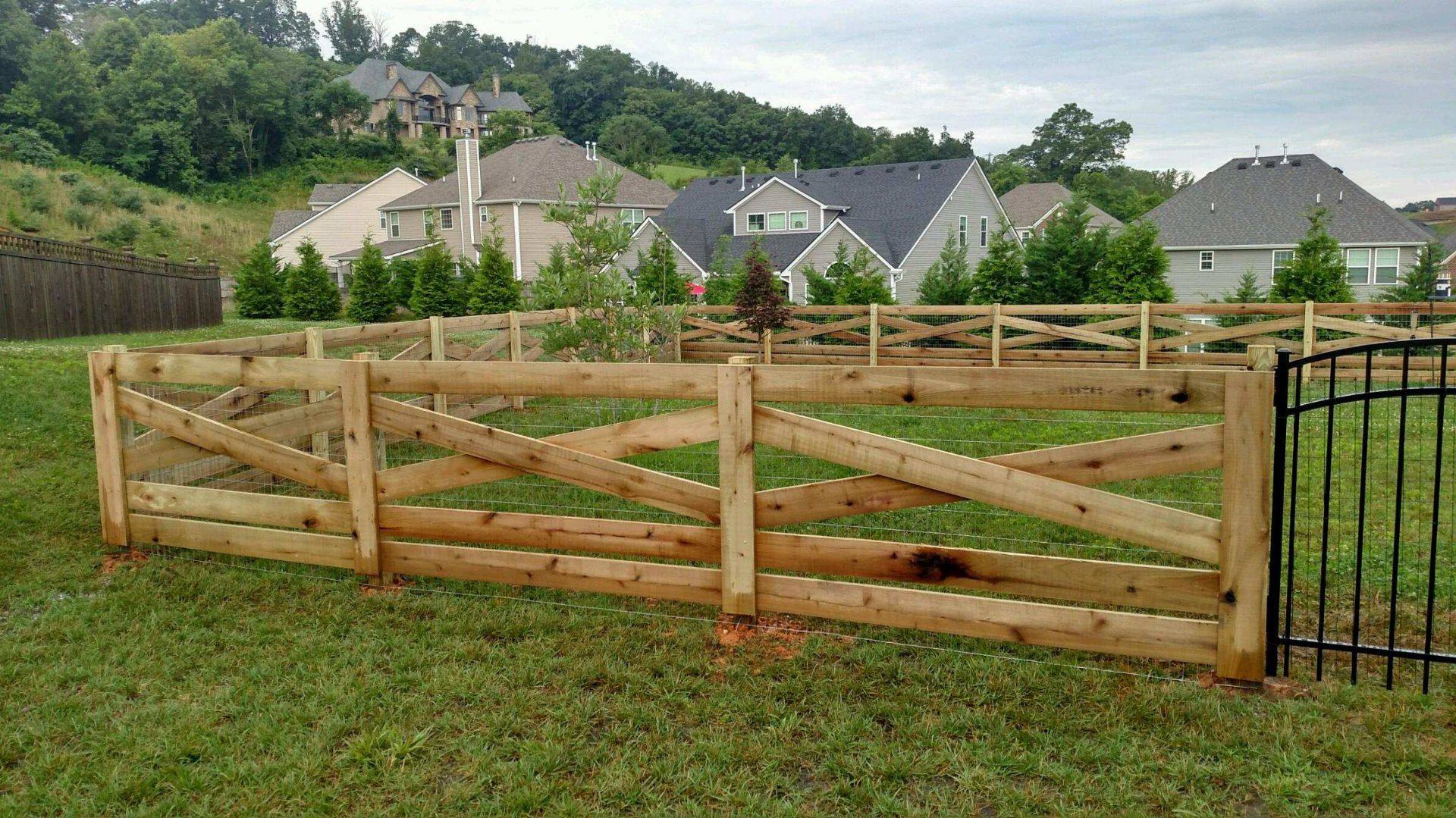 Crossbuck wood rail fence around a backyard in a hillside neighborhood