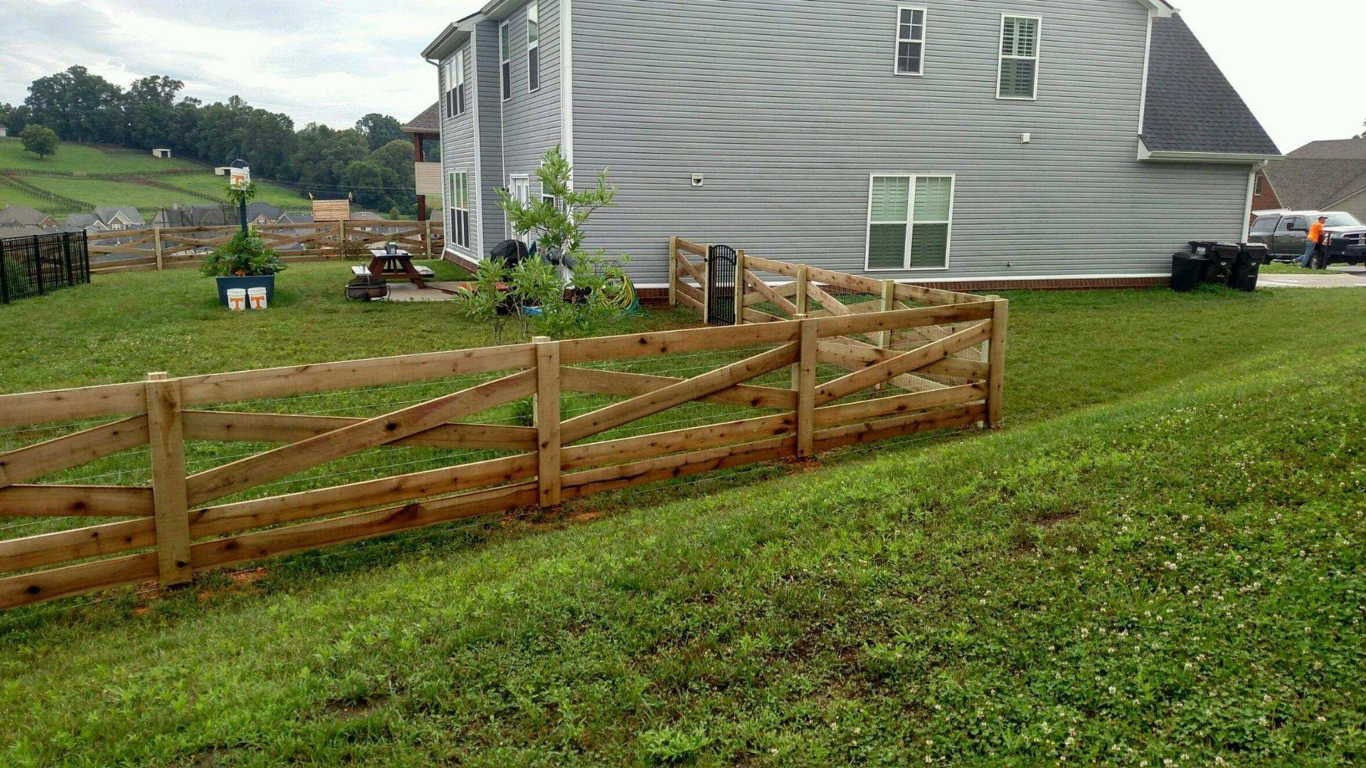 Crossbuck wood fence following the slope of a yard