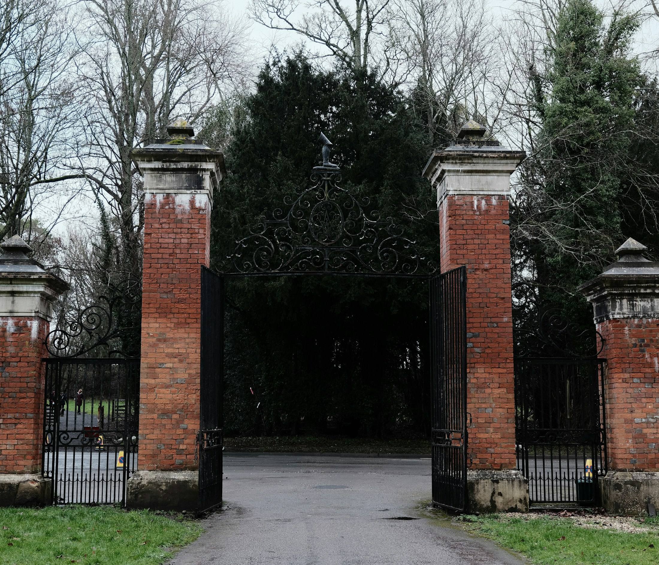 Iron driveway gates between brick pillars