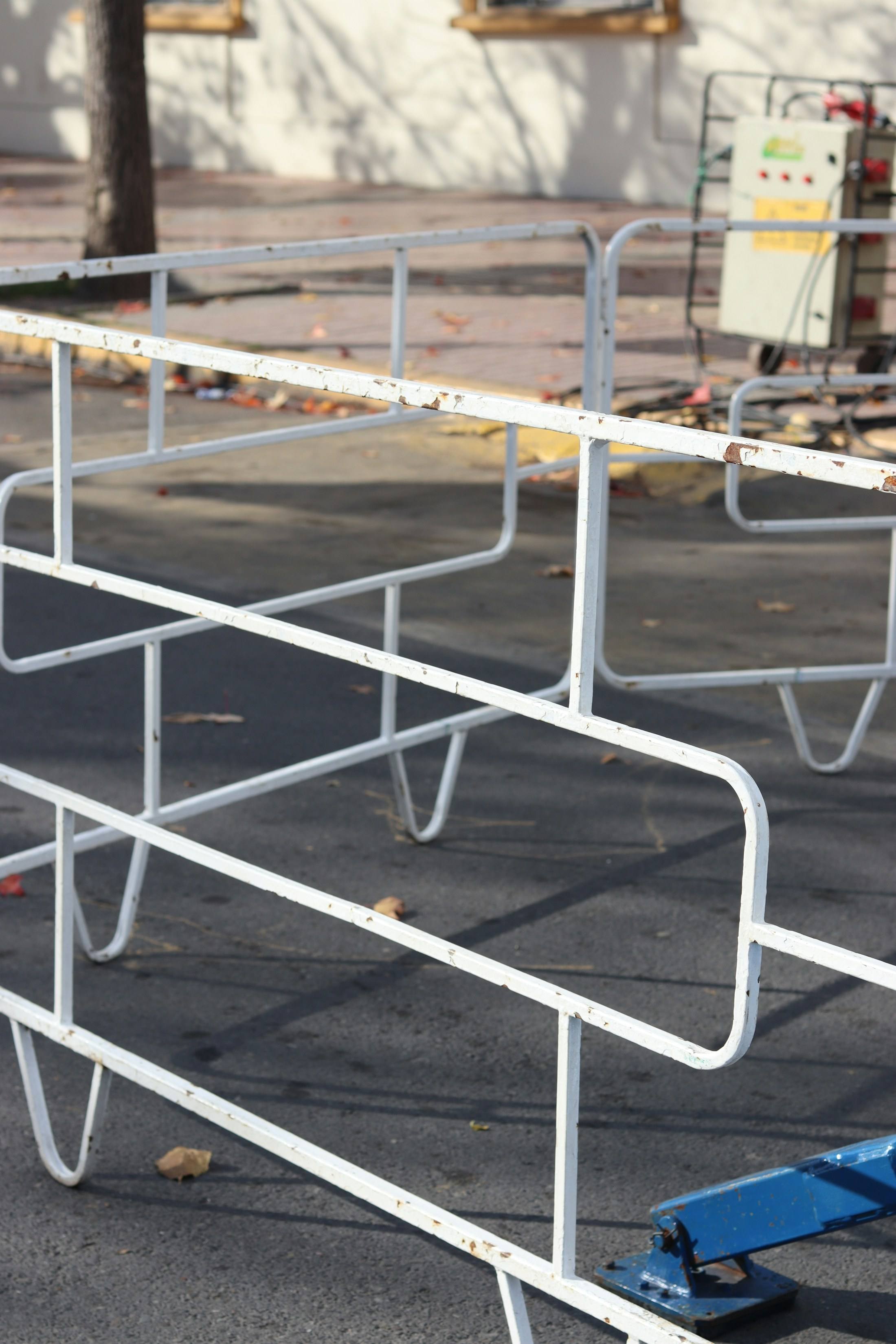 White metal crowd control barriers on pavement